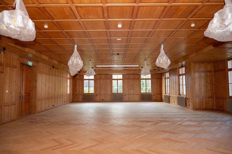 Sanierung des denkmalgeschützten Hotel Kreuz in Romoos – Nachher | Festsaal | Hist. Kassetten wieder montiert | Kronleuchter revidiert | Fischgratparkett Romooser Holz